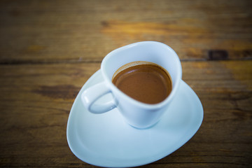 Hot coffee in a white cup on table