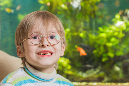 Boy in glasses wiyh aquarium on background
