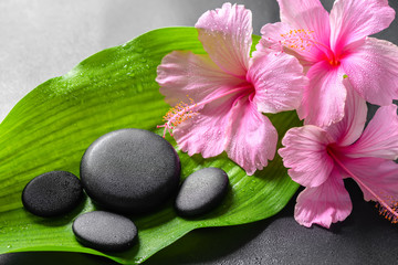 beautiful spa concept of pink hibiscus flowers and zen basalt st