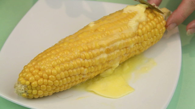 Spreading butter on a hot cob of corn straight from the oven.
