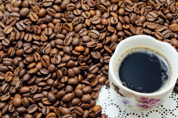 Cup with coffee beans on coffee beans