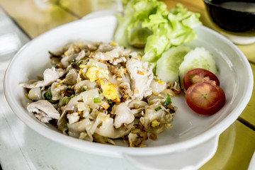Fired thin noodles with soy sauce and salads in a white dish. 
