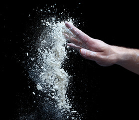 Fototapeta na wymiar the man's hand and a handful of flour