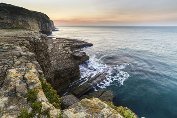 Stunning coastal landscape with long exposure waves crashing at