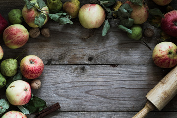 Autumn border from apples, pears and walnuts on old wooden table. Fall, Thanksgiving day and baking concept