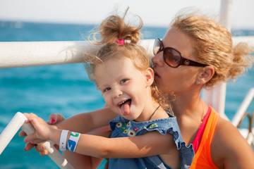 little girl with mother looking at sea