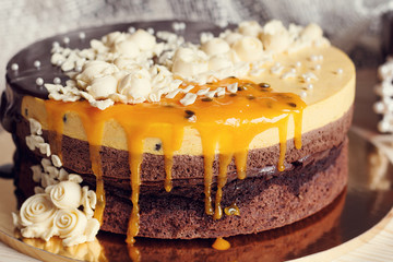 Romantic cake with chocolate glaze, cream flowers and  mango pas
