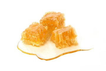 cutout of 3 honeycomb cubes full of honey and dripping honey sirup