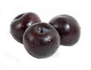 Three ripe plums isolated on white