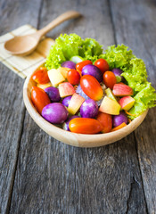 Fresh vegetable salad on wooden background.