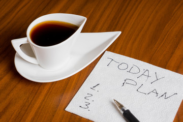 Obraz na płótnie Canvas coffee cup with handwriting today plan on napkin