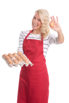 Hausfrau in Küchenschürze zeigt ein Hühnerei
