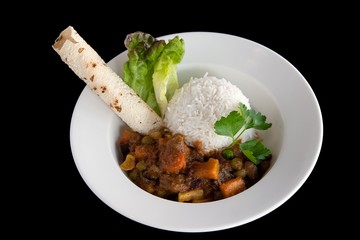 Bowl of Indian vegetable curry with rice and naan