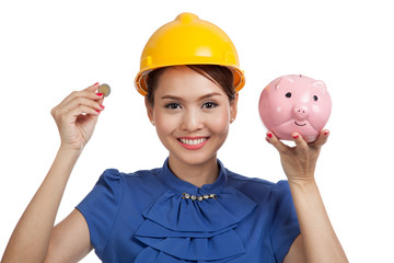 Asian engineer woman with a coin and piggy coin bank