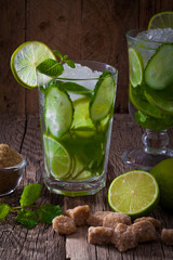 Fresh mojito cocktail with cucumber on a wooden table
