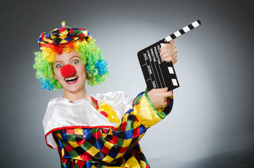 Clown with movie clapper in funny concept