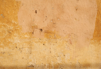 Texture of old wall covered with yellow stucco