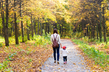 Fototapeta premium Young mother walking with her baby in an autumn park