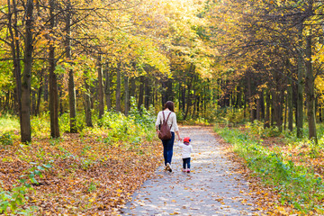 Fototapeta premium Young mother walking with her baby in an autumn park