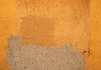 Texture of old wall covered with yellow stucco