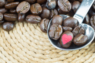Coffee beans in metallic spoon and background with clipping path