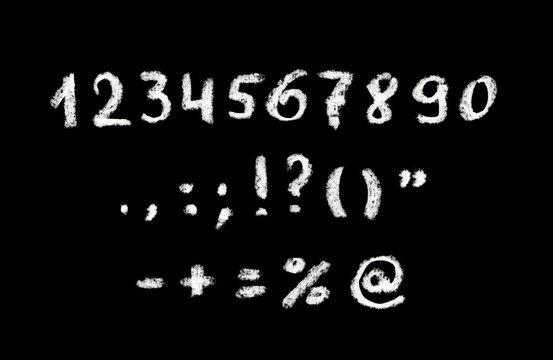 Chalk hand written numbers and punctuation marks on black board
