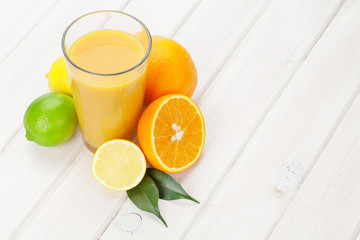 Citrus fruits and glass of juice. Oranges, limes and lemons