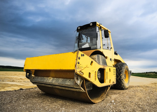 Radwalze und dunkle Wolken auf Baustelle