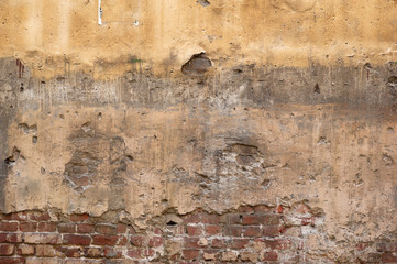 Texture of old wall covered with yellow stucco