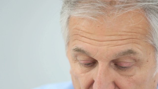 Closeup of senior man putting contact lens