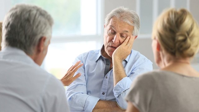 Senior man attending meeting with group therapist