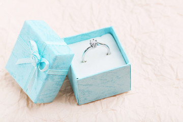Diamond ring in box on pink background