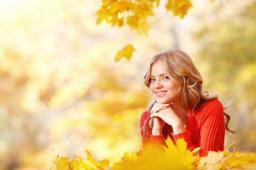 Naklejka na ściany i meble Woman lying in autumn leaves