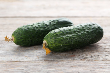 Fresh cucumbers on grey wooden background