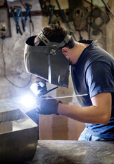 Welder doing welding in a metal workshop