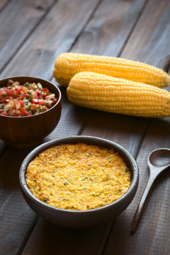 Traditional Chilean corn pie Pastel de Choclo served with Pebre sauce, photographed with natural light. Below the corn-basil mix is ground meat, olive, boiled egg, raisin, chicken