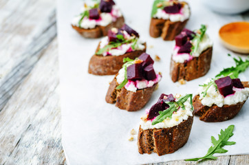 Obraz na płótnie Canvas beet goat cheese arugula walnut honey crostini