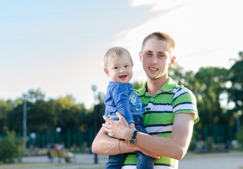Fototapeta premium young father is holding his little son
