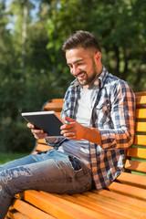 Fototapeta premium Young man working on tablet PC outdoors