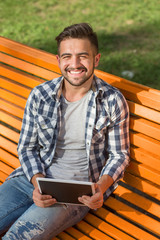 Fototapeta premium Young man working on tablet PC outdoors
