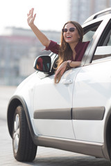 Fototapeta na wymiar Beautiful lady waving from her car