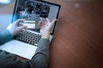 top view of hands using laptop and holding credit card with soci