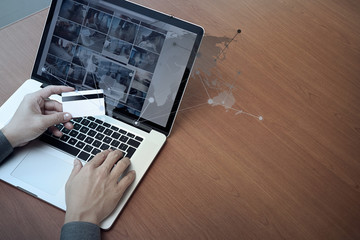 top view of hands using laptop and holding credit card with soci