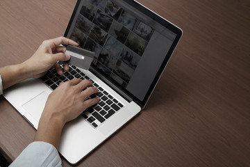 top view of hands using laptop and holding credit card with soci