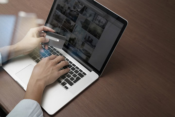 top view of hands using laptop and holding credit card with soci