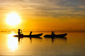 Family kayaking at sunset