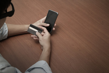 hands using mobile phone and holding credit card with social med