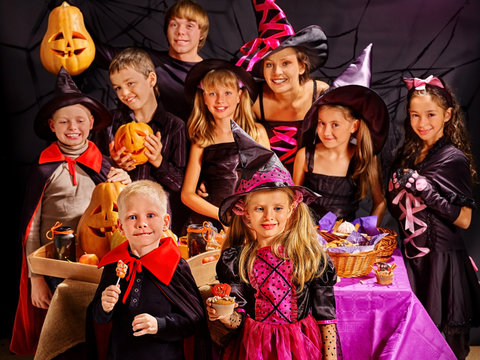 Children on Halloween party making pumpkin