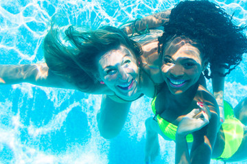 Friends diving underwater in swimming pool