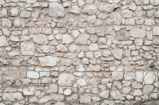 Old wall made of irregular limestone stones